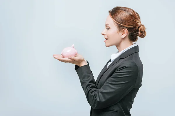 Vista laterale di attraente finanziere che tiene salvadanaio isolato su grigio — Foto stock