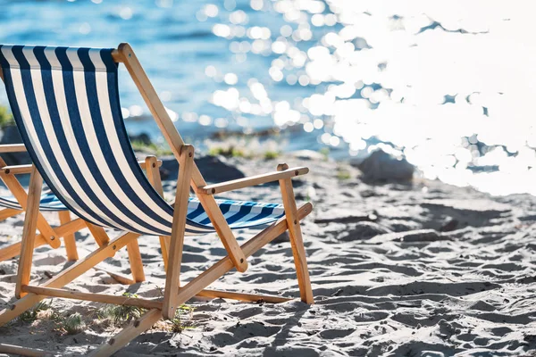 Chaise lounges on beautiful empty sandy beach — Stock Photo