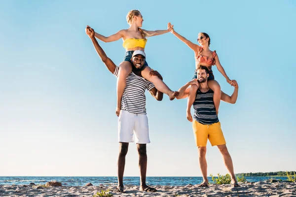 Felices jóvenes amigos multiétnicos divirtiéndose juntos en la playa de arena - foto de stock