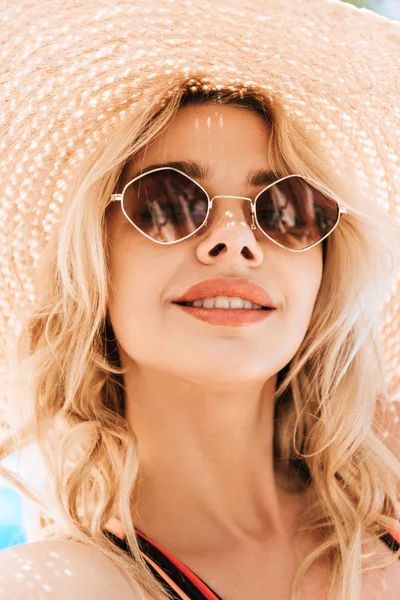 Retrato de hermosa joven rubia sonriente en gafas de sol y sombrero de mimbre - foto de stock
