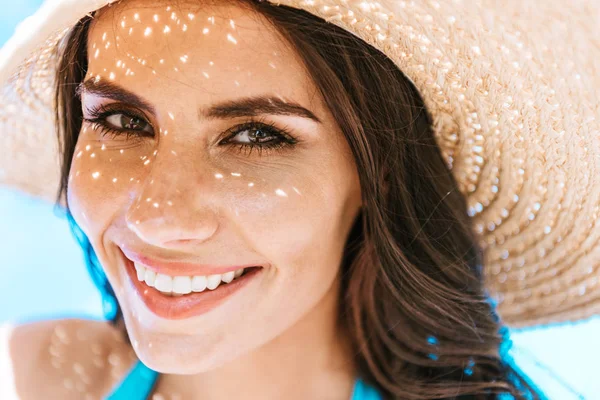 Bella donna bruna in cappello di paglia sorridente alla macchina fotografica — Foto stock