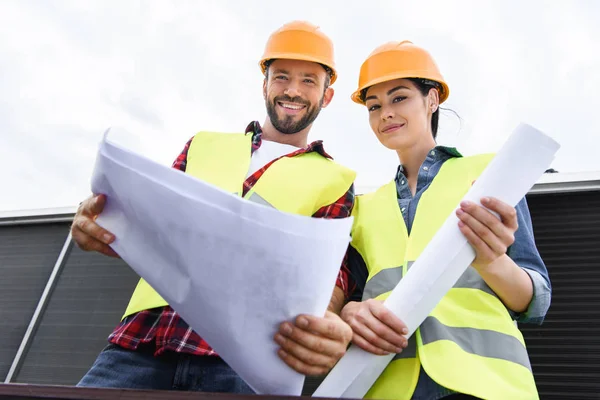 Vista dal basso di architetti in hardhat che lavorano con cianografie — Foto stock