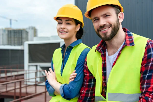 Professional engineers in hardhats and safety vests on roof — Stock Photo