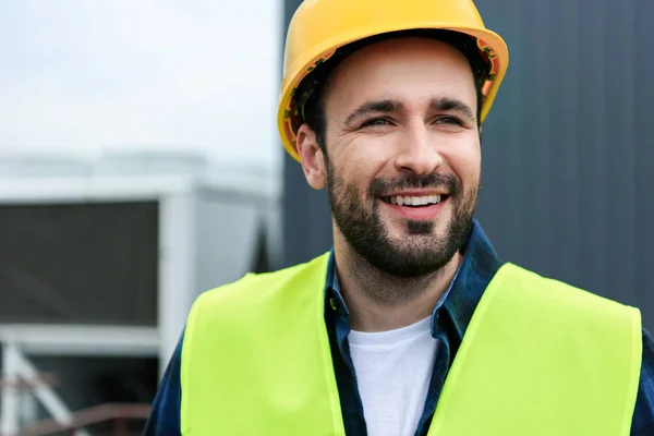 Portrait of cheerful male engineer in safety vest and helmet — Stock Photo