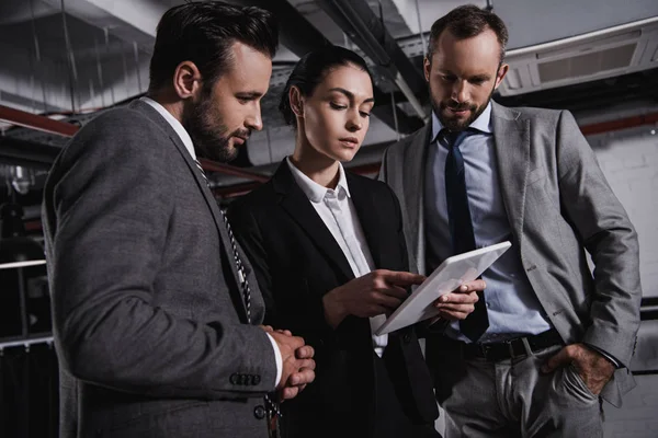 Businesspeople in suits working with digital tablet together — Stock Photo