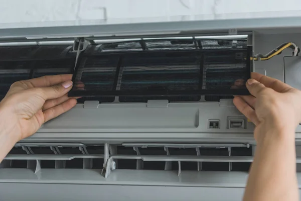 Ausgeschnittene Ansicht einer Arbeiterin, die eine Klimaanlage repariert — Stockfoto