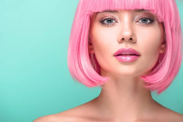 Retrato de cerca de una mujer joven con corte rosa bob mirando a la cámara aislada en turquesa - foto de stock