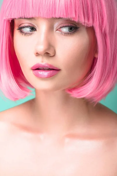 Portrait en gros plan de jeune femme avec une coupe rose bob regardant côté isolé sur turquoise — Photo de stock