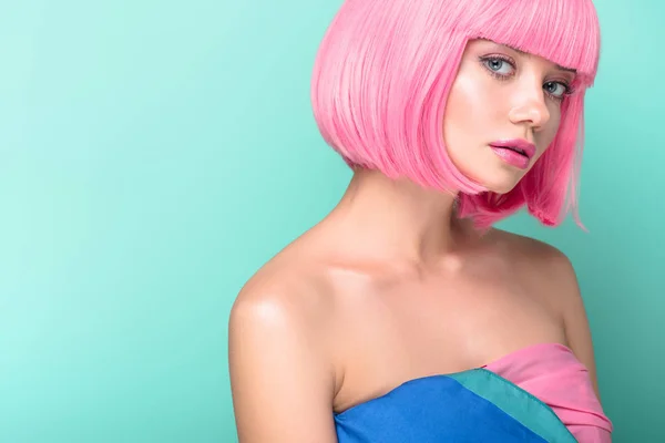 Attractive young woman with pink bob cut looking at camera isolated on turquoise — Stock Photo