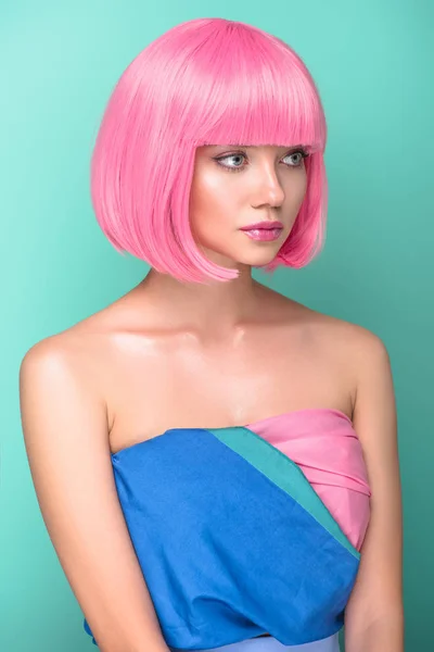 Beautiful young woman with pink bob cut looking away isolated on turquoise — Stock Photo