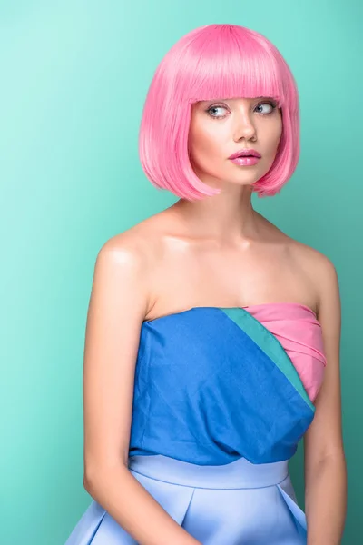 Beautiful young woman with pink bob cut and dress looking away isolated on turquoise — Stock Photo