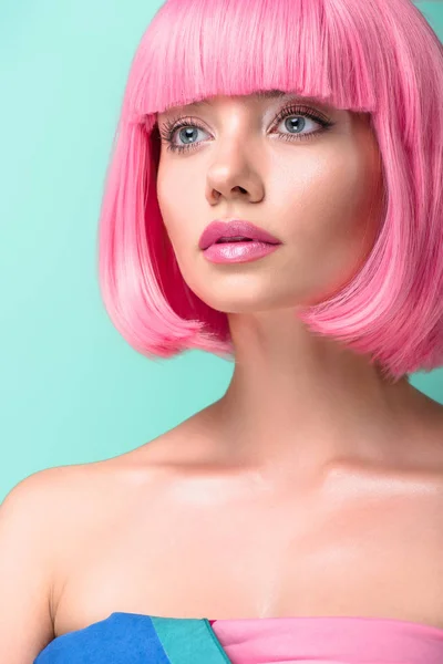 Close-up portrait of young woman with pink bob cut looking away isolated on turquoise — Stock Photo