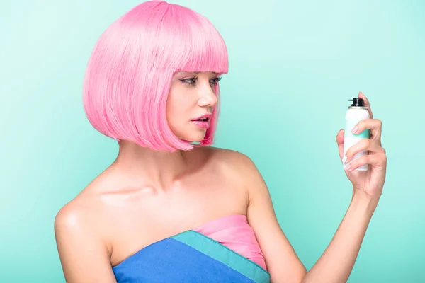 Bela jovem com corte bob rosa segurando spray de cabelo coloração isolada em turquesa — Fotografia de Stock