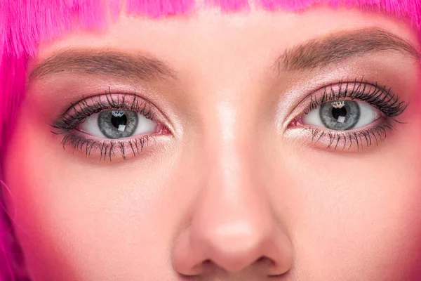 Частичный вид красивой молодой женщины с розовыми волосами, смотрящей в камеру — стоковое фото