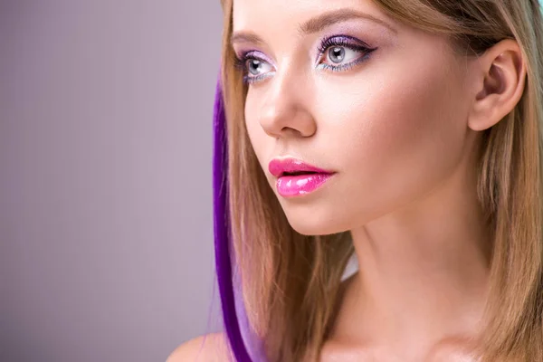 Retrato de cerca de la hermosa mujer joven con hebras de colores en el pelo mirando hacia otro lado - foto de stock