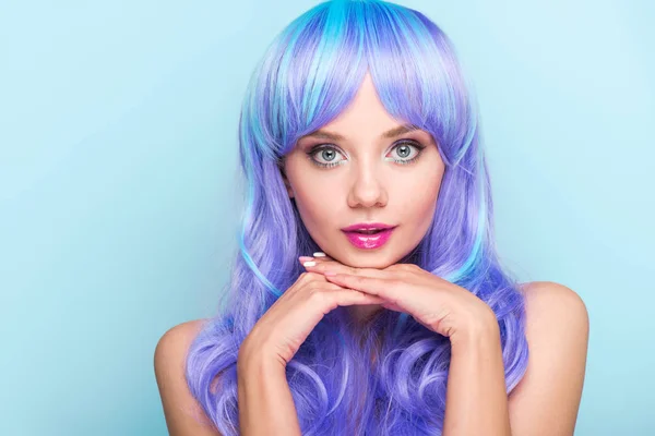 Élégant jeune femme avec les cheveux bleus regardant caméra isolée sur bleu — Photo de stock