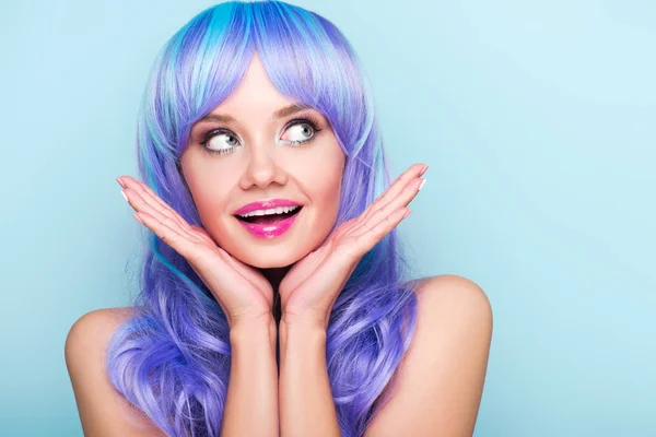 Excited young woman with blue hair looking looking away isolated on blue — Stock Photo