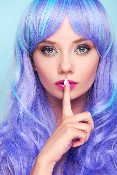 Close-up retrato de atraente jovem com cabelo azul encaracolado mostrando gesto de silêncio isolado no azul — Fotografia de Stock