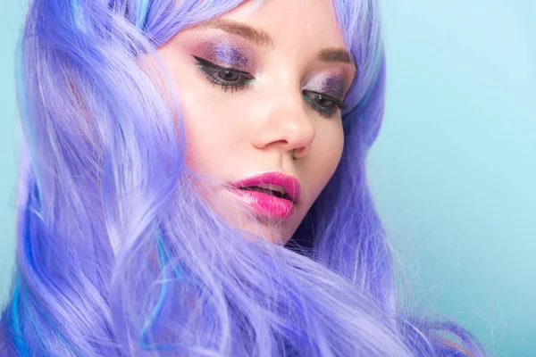 Portrait en gros plan d'une jolie jeune femme aux cheveux bouclés bleus isolés sur bleu — Photo de stock