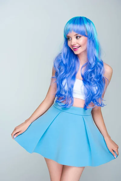 Mujer joven feliz con el pelo azul brillante aislado en gris - foto de stock