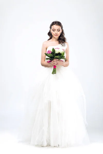 Schöne junge Braut im Brautkleid mit Strauß auf weißem Grund — Stockfoto