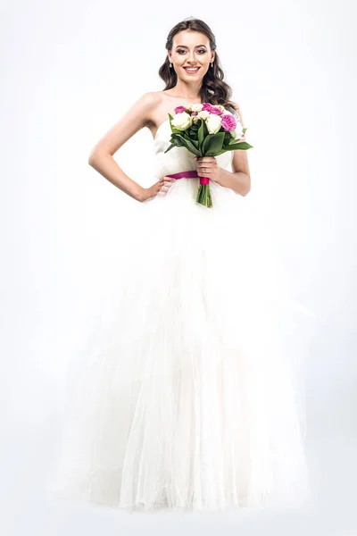 Joyeux jeune mariée en robe de mariée avec bouquet sur blanc — Photo de stock