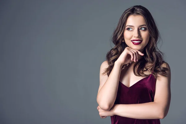 Beautiful young woman in stylish dress looking away isolated on grey — Stock Photo