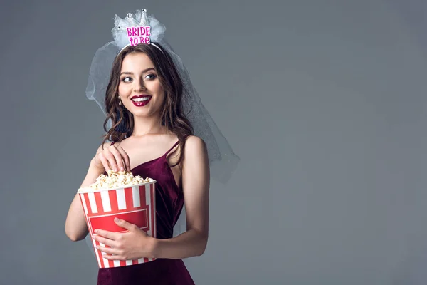 Bella futura sposa in velo per addio al nubilato mangiare popcorn isolati su grigio — Foto stock
