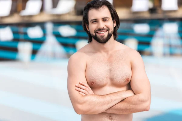Homem barbudo de pé com braços cruzados na piscina — Fotografia de Stock