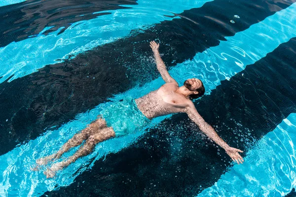 Homem barbudo flutuando na piscina — Fotografia de Stock