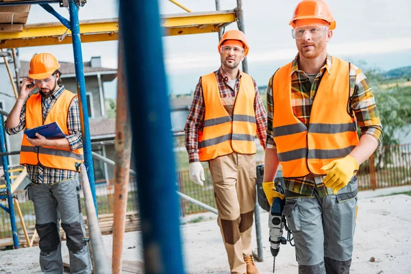 Grupo de construtores que trabalham em conjunto no estaleiro — Fotografia de Stock