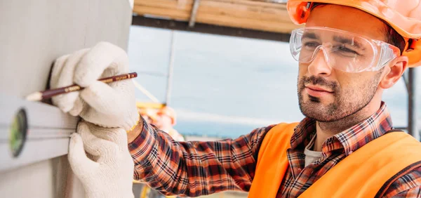 Ampio colpo di bel costruttore utilizzando il livello della bolla in cantiere — Foto stock