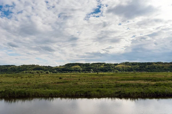 Vue panoramique de la belle rivière en face du champ vert — Photo de stock
