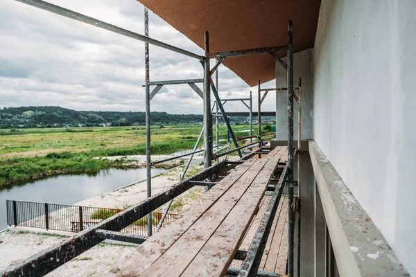 Échafaudage du chantier de construction du bâtiment moderne près de la rivière — Photo de stock