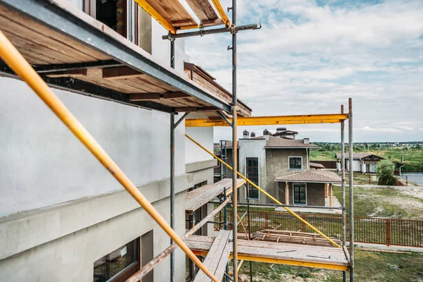 Andamios del sitio de construcción del edificio moderno bajo el cielo nublado - foto de stock