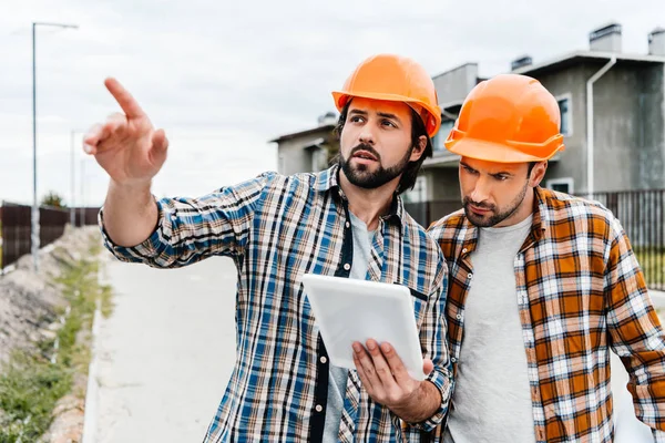 Arquitectos usando tableta digital y apuntando a algún lugar - foto de stock