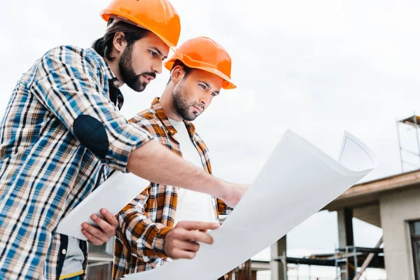 Selbstbewusste Architekten arbeiten mit Bauplan zusammen — Stockfoto