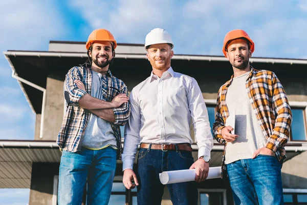 Grupo de arquitetos bonitos em frente ao canteiro de obras — Fotografia de Stock