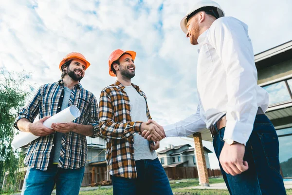 Gruppo di architetti che conversano in giardino in cantiere — Foto stock