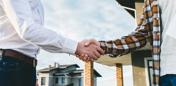 Recortado disparo de arquitectos estrechando la mano en frente de la obra - foto de stock