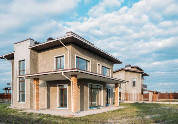 Edificios de hormigón moderno inacabados con patios verdes bajo el cielo nublado - foto de stock