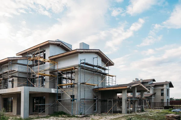 Modern building construction with scaffolding under cloudy sky — Stock Photo