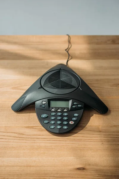 High angle view of speakerphone on wooden table at office — Stock Photo