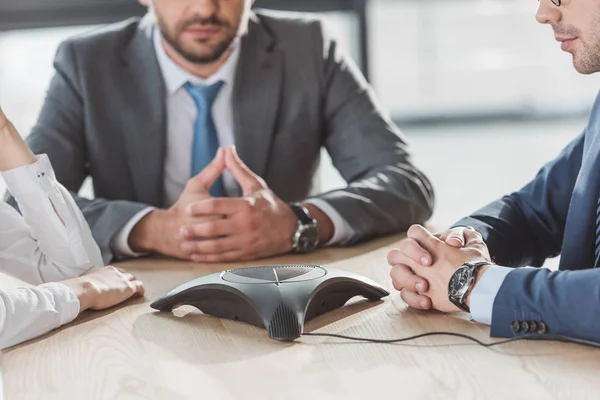 Cropped shot of confident business people using conference phone — Stock Photo