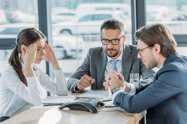 Sérieux gens d'affaires ayant une conversation et en utilisant haut-parleur au bureau moderne — Photo de stock