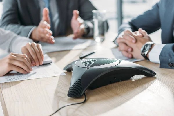 Plan recadré de gens d'affaires ayant une conversation et en utilisant haut-parleur au bureau moderne — Photo de stock