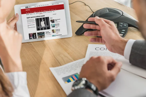 Cropped shot of businessman and businesswoman looking at tablet, bbc website on screen — Stock Photo