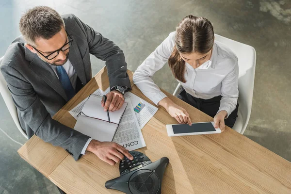 Blick aus der Vogelperspektive auf erfolgreiche Geschäftsfrau und Geschäftsfrau, die im modernen Büro mit Tablet und Lautsprecher zusammenarbeiten — Stockfoto