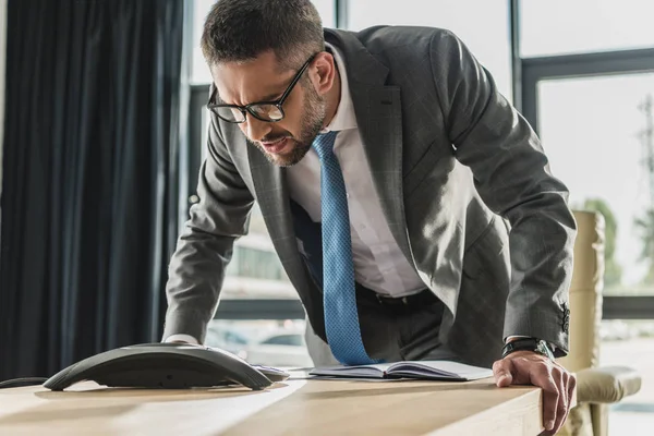 Homme d'affaires adulte en colère criant au haut-parleur au bureau moderne — Photo de stock