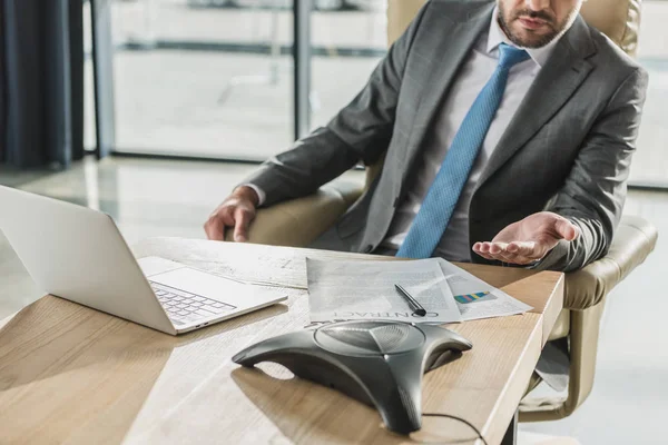 Обрізаний знімок бізнесмена з ноутбуком і контрактом з використанням акустичного телефону в офісі — стокове фото